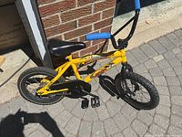Right side view of yellow Sportek Bandit bike showing frame, wheels, pedals, chain guard
