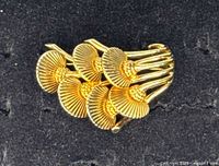 Front view of gold-tone fan-shaped mushroom brooch showing design details