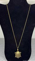 Full view of brass turtle pendant necklace displayed on bust