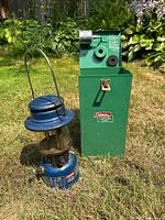 Lantern and closed green case on lawn