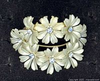 Front view showing white petal flowers with rhinestone centers