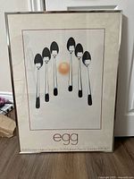 Full view of framed poster showing spoons and egg design