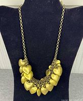 Full view of gold-tone puffy heart charm necklace on display form