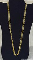 Full view of entire gold-tone chain necklace on display bust