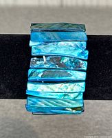 Front view of bracelet on display stand showing shell tiles