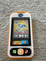 Front view of VTech Touch & Swipe Baby Phone showing dog screen image and control buttons