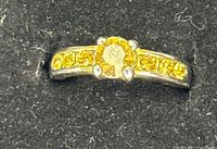Top view showing yellow center stone and accent stones on band