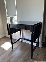 Desk with sides collapsed, showing compact size and drawer front.