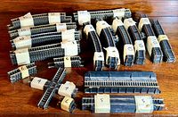 Photo showing neatly bundled straight and curved HO scale Bachmann train track pieces with quantities labeled on tape.
