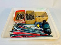 Tray containing multiple straight ink calligraphy pens, two boxes full of assorted nibs, a boxed Waterman ink pen refill tank, and a bottle of ink.