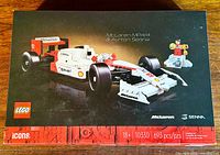 Box front showing assembled McLaren MP4/4 car and Ayrton Senna minifigure with trophy, LEGO and McLaren branding, 693 pieces, 18+ age recommendation.