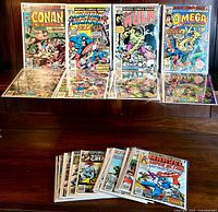Front view of 20 vintage Marvel comic books including Conan the Barbarian, Captain America and the Falcon, Hulk, Omega the Unknown, and Defenders in protective bags with backing boards.