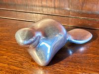 Close-up angled photo showing the smooth polished form of the beaver sculpture with visible patina and shape details.