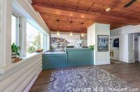 Reception area with green front desk, wood-paneled ceiling and large window