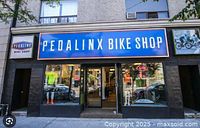 Exterior storefront with Pedalinx Bike Shop signage above entrance