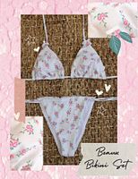 Photo of a floral print bikini set with triangle top and side-tie bottoms, shown on a woven surface.