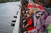 Actors and families interacting on a pirate ship during the adventure, showing children and adults enjoying water cannons.