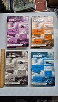 Four hardcover books titled U.S. Civil Aircraft volumes 6-9 spread on a flat surface showing front covers with aircraft images and volume numbers.