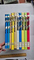 Top view of 10 Air International hardcover volumes (vols 36, 38, 39, 40, 41, 53, 54, 55, 56, 57) showing colorful dust jackets and vertical titles on spines, with volume numbers and publication years/months.