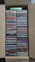 Box filled with various music CDs stacked neatly inside