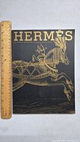 Front cover of 2010 Hermès catalogue showing gold foil illustration of a horse with decorative tack and the Hermès logo in large gold lettering.