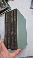 Photo showing four volumes of 'Our World' book set in slipcase, spines visible with titles and author name Aleksei Eriashvili.