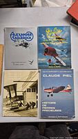 Four vintage aviation books laid out on a table, showing covers and titles clearly.