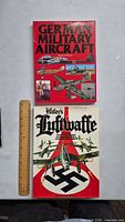 Front covers of two vintage German military aircraft books, one red and one white with black swastika