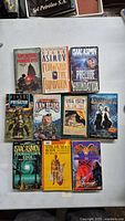 Photo showing 10 vintage sci-fi paperback books arranged on a white surface, including multiple Isaac Asimov titles.