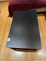 Top view of the black wood coffee table showing smooth surface and rectangular shape.