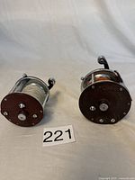 Two vintage Penn Peer fishing reels side by side showing lines wound on spool and crank handles.