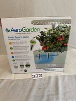 Front of AeroGarden Harvest box showing product details such as growing plants in water without soil, energy efficient LED grow lights, and capacity for 6 pods.