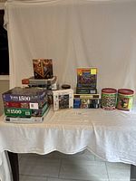 Wide view showing all puzzle boxes and tins on a white cloth-covered table.