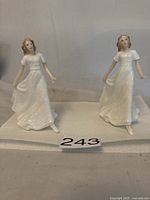 Pair of Royal Doulton Sentiments Friendship figurines together, viewed from the front, showing details of the dresses and posture.