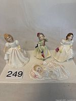 Four Royal Doulton figurines displayed on white surface, showing Amanda, Barbie, Lynsey, and New Baby characters.