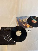 Two Supertramp vinyl albums Crime of the Century and Breakfast in America with covers and records visible on a white backdrop.