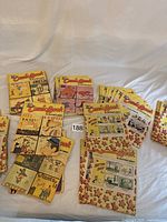 Overview of multiple vintage The Trib Comic Book issues stacked and spread out on a white sheet.