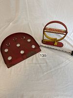 Both vintage metal games displayed side by side on white backdrop with measuring ruler for scale.