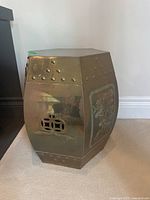 Full view of the hexagonal brass garden stool or side table showing polished brass surface, studded details and overall shape.