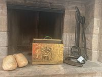 Wide view showing wooden shoes, brass finish magazine rack with embossed scene, and fireplace tool set on hearth.