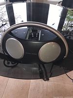 Front view of the Harman Kardon docking station showing dual speaker grills and docking port.