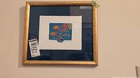 Full framed lithograph print with gold frame showing fish, coral, and nautilus shell artwork.