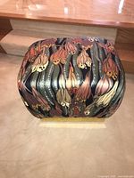 Front angle showing the upholstering floral fabric with varied colored petals and leaves.