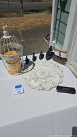 Full overview of all antique and decorative items on white tablecloth near a porch with outdoor setting