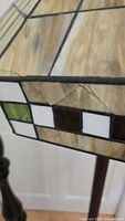 Close-up photo showing small cracks in the stained glass shade of the floor lamp.