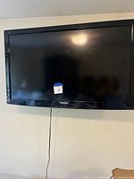 Front view of Panasonic flat screen TV with black bezel, mounted on wall.