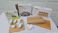 Full set of the tasting party items arranged: wooden tray, the ceramic tasting spoons, heart-shaped bowl, and cookbooks in the background.