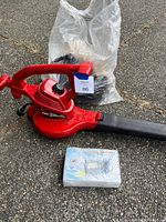Red Toro Ultra Blower Vac leaf blower/vacuum with collection bag and bubble wrapped battery radio on pavement