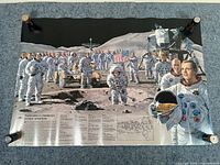 Photo showing full view of space poster with astronauts, lunar rover, module, and text