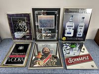 Image showing six framed bar mirror signs featuring various alcohol brands arranged on a table.